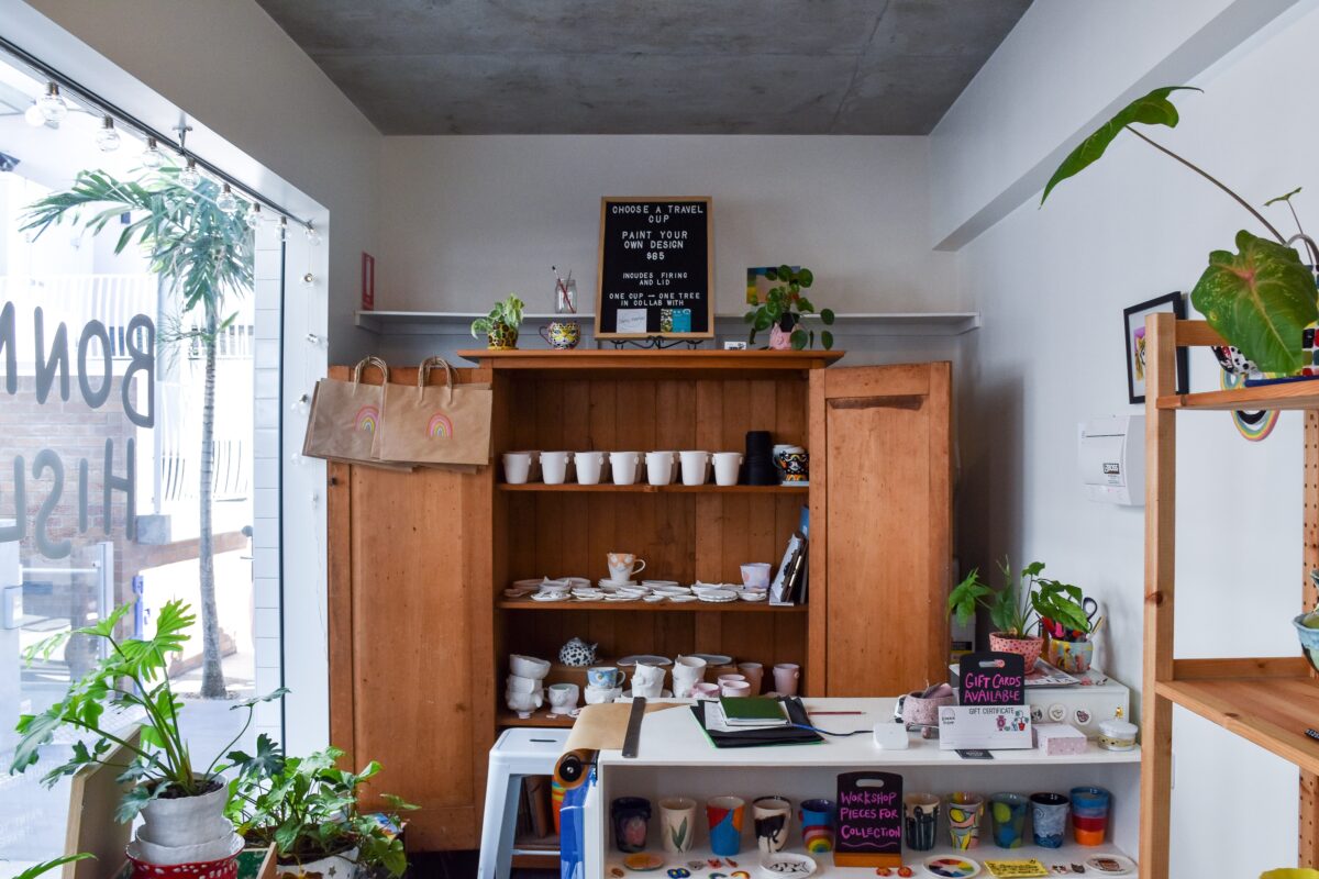 A boutique goods store with homemade ceramics plants and a work bench